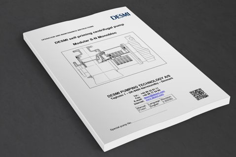 Manual for DESMI selvansugende centrifugalpumpe, Modular S-N Monobloc, på et bord.