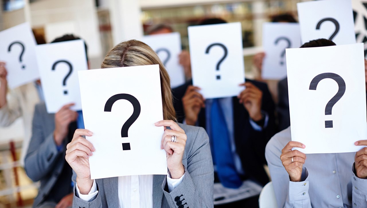 Personer, der holder papirer med spørgsmålstegn, der dækker deres ansigter.