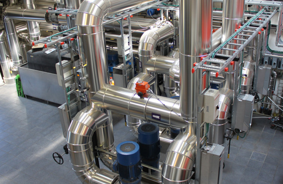 Industriel facilitet med rustfri stålrør og maskiner, designet til håndtering af væsker.