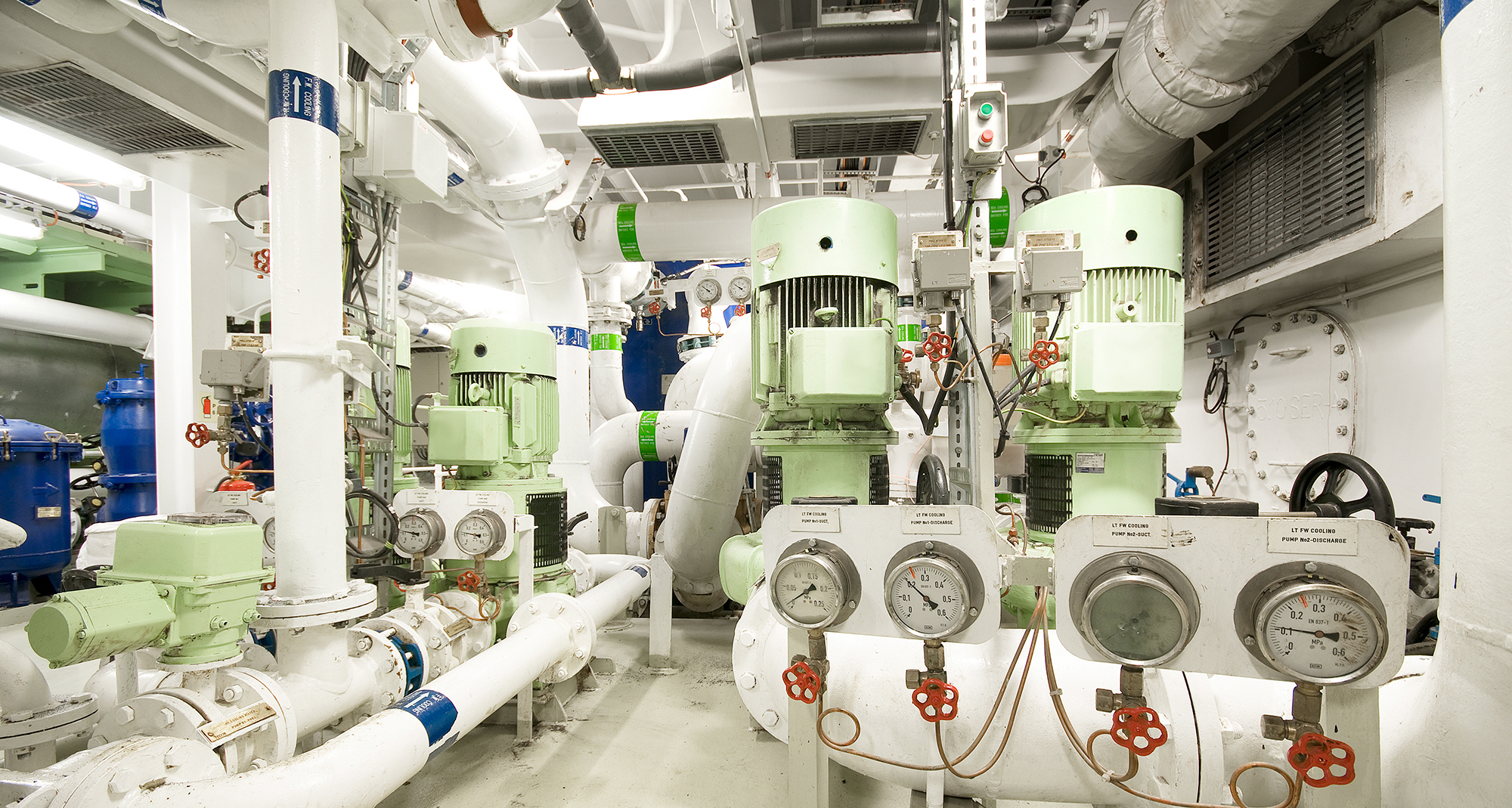 Industrielt rum med flere pumper og måleinstrumenter til væskehåndteringssystemer.