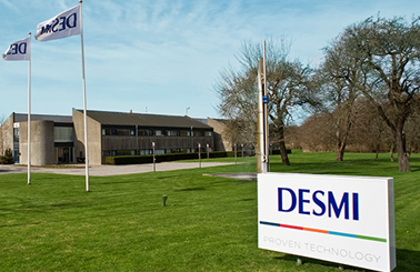 DESMI hovedkvarter med flag og skiltning på en solrig dag.