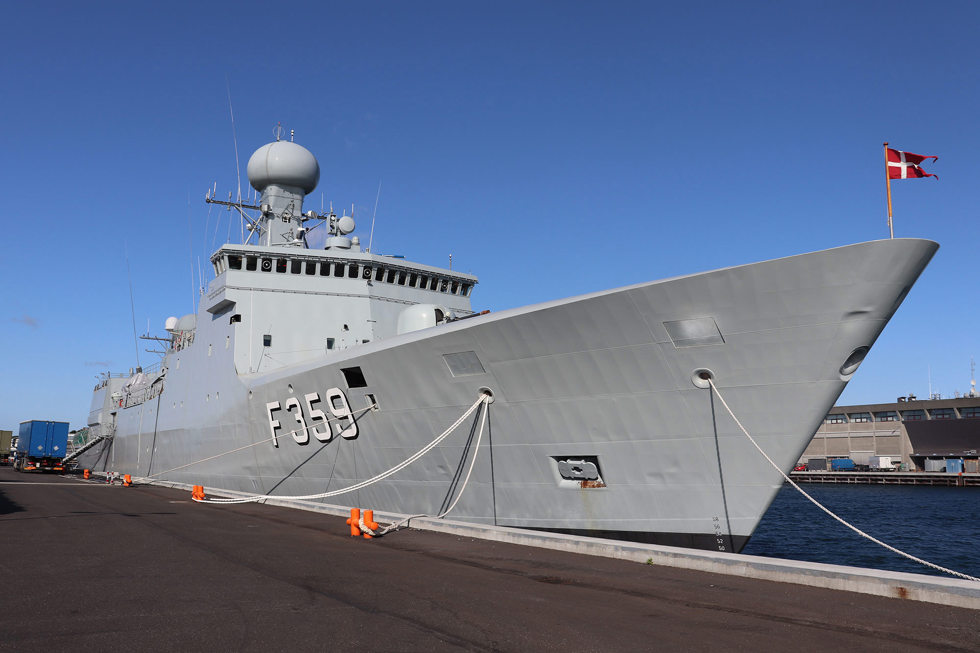 Et flådeskib ved kajen, der viser det danske flag.
