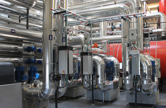 Industriel facilitet med store metalrør og maskineri til håndtering af væsker.