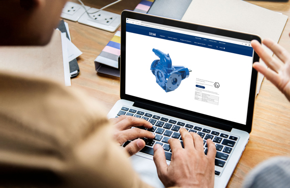 Person ser på DESMI pumpens produktside på en laptops skærm ved et skrivebord.