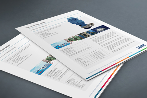 DESMI brochure sider med specifikationer for industrielle pumper på en grå overflade.