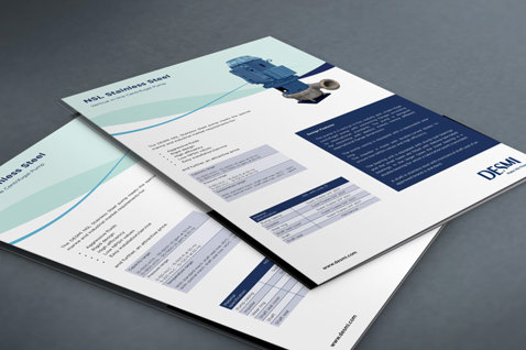 DESMI brochure sider med specifikationer for industrielle pumper på en grå overflade.