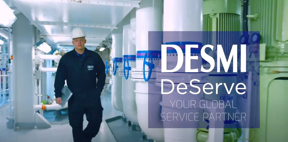 Medarbejder i DESMI-uniform går gennem en industriel facilitet til håndtering af væsker.