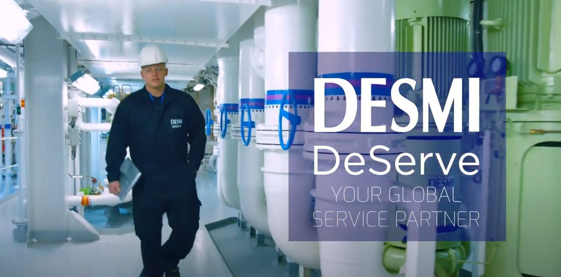 Medarbejder i DESMI-uniform går gennem en industriel facilitet til håndtering af væsker.
