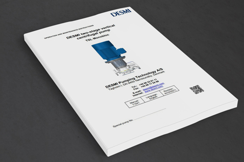 DESMI instruktionsmanual for TBL MonoBloc centrifugalpumpe på en grå overflade.