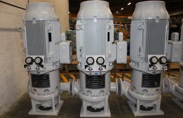 Tre store DESMI lodrette pumper med målere, anvendt til væskehåndteringsapplikationer.