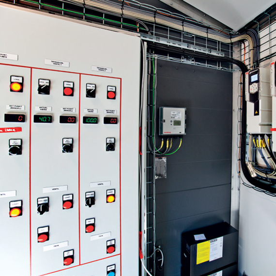 Kontrolpanel med målere og kontakter til industrielt væskehåndteringssystem.