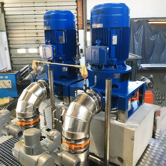 Blå DESMI-pumper til industriel væskehåndtering, med metalrørsforbindelser.