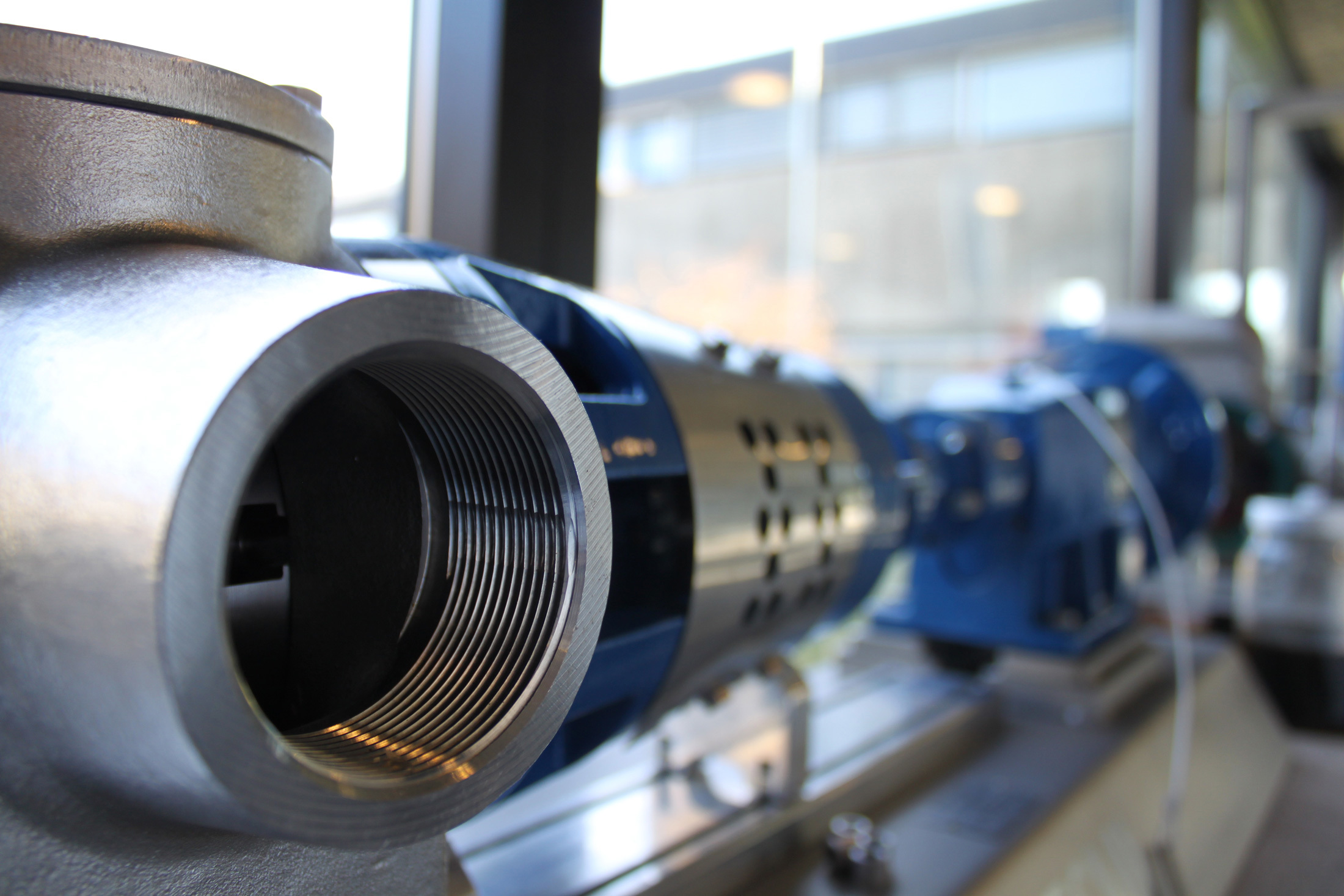 Nærbillede af en DESMI industriel pumpe til væskehåndtering i et værksted.